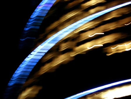 Blurred blue and gold light streaks curve diagonally across a dark background.
