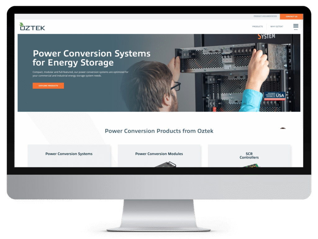 Computer screen displaying Oztek’s manufacturing website design about power conversion systems, with a person installing equipment.