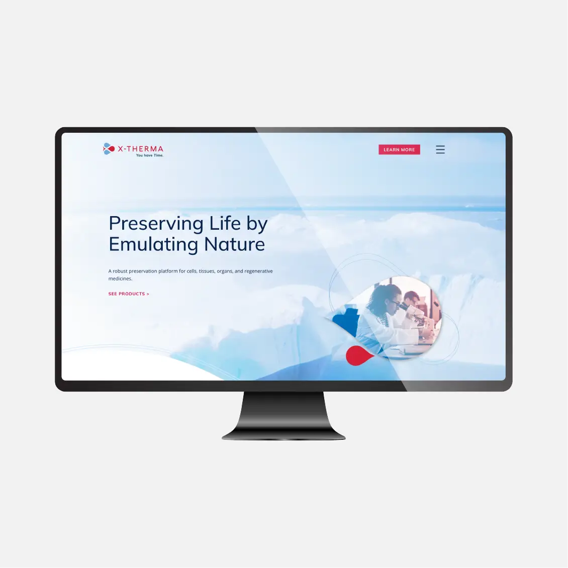 A computer monitor displays the X-Therma website homepage with the text &ldquo;Preserving Life by Emulating Nature.&rdquo;.