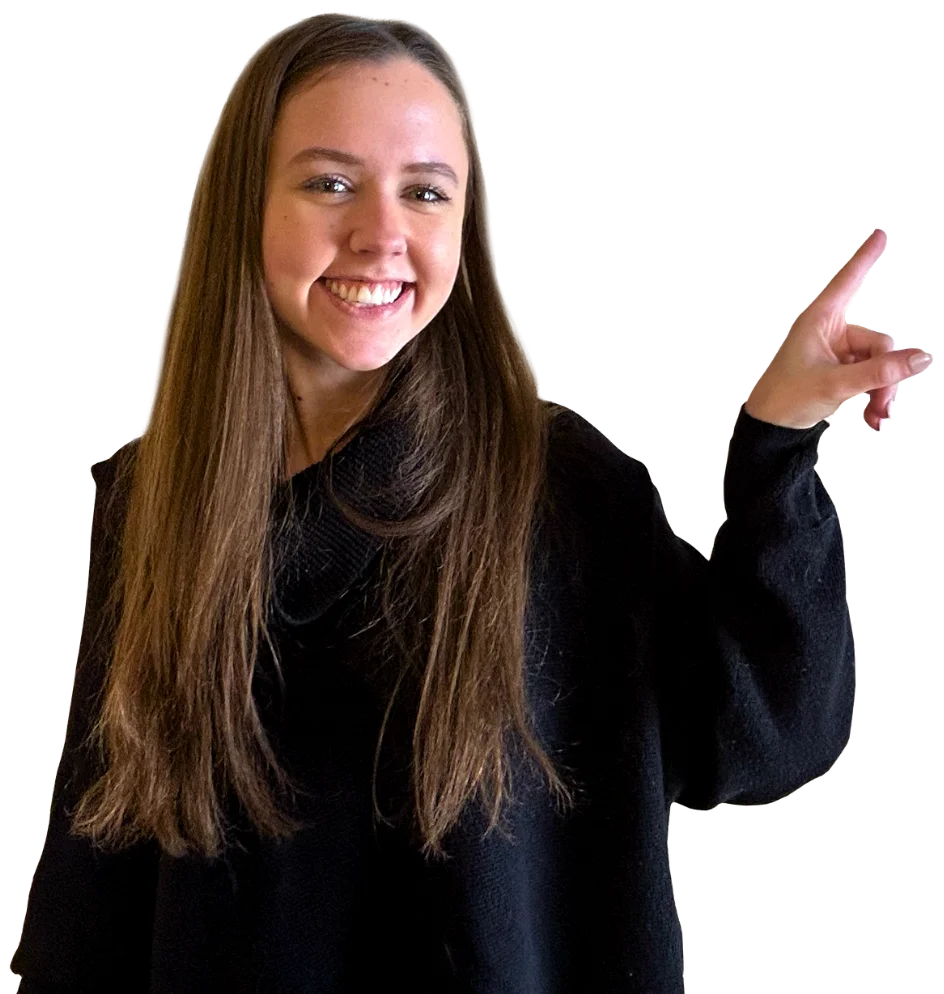 Smiling woman with long brown hair in a black sweater, pointing up and to the right on a white background, embodying a confident and inviting marketing vibe.